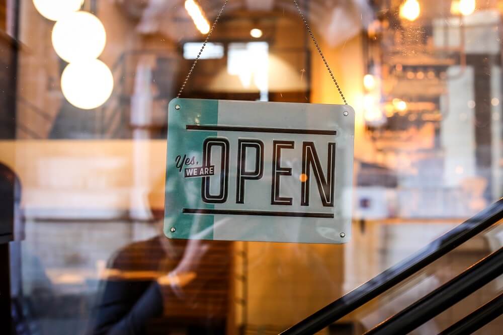Schild an Ladentür: Yes, we are open