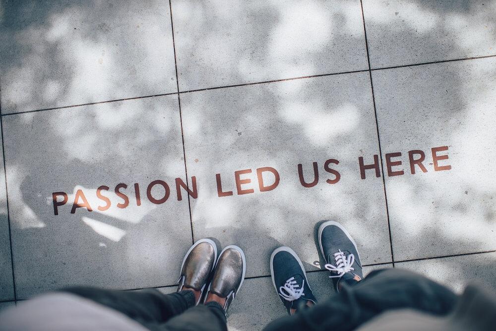 2 Menschen vor dem Schriftzug "Passion led us here"